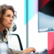 a woman is sitting in front of a computer monitor