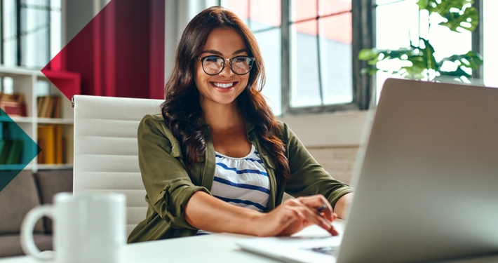 a woman is sitting at a desk using a laptop computer