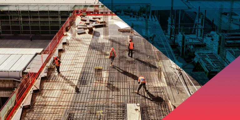 Aerial view of construction workers in safety vests and hard hats installing a dense steel rebar grid