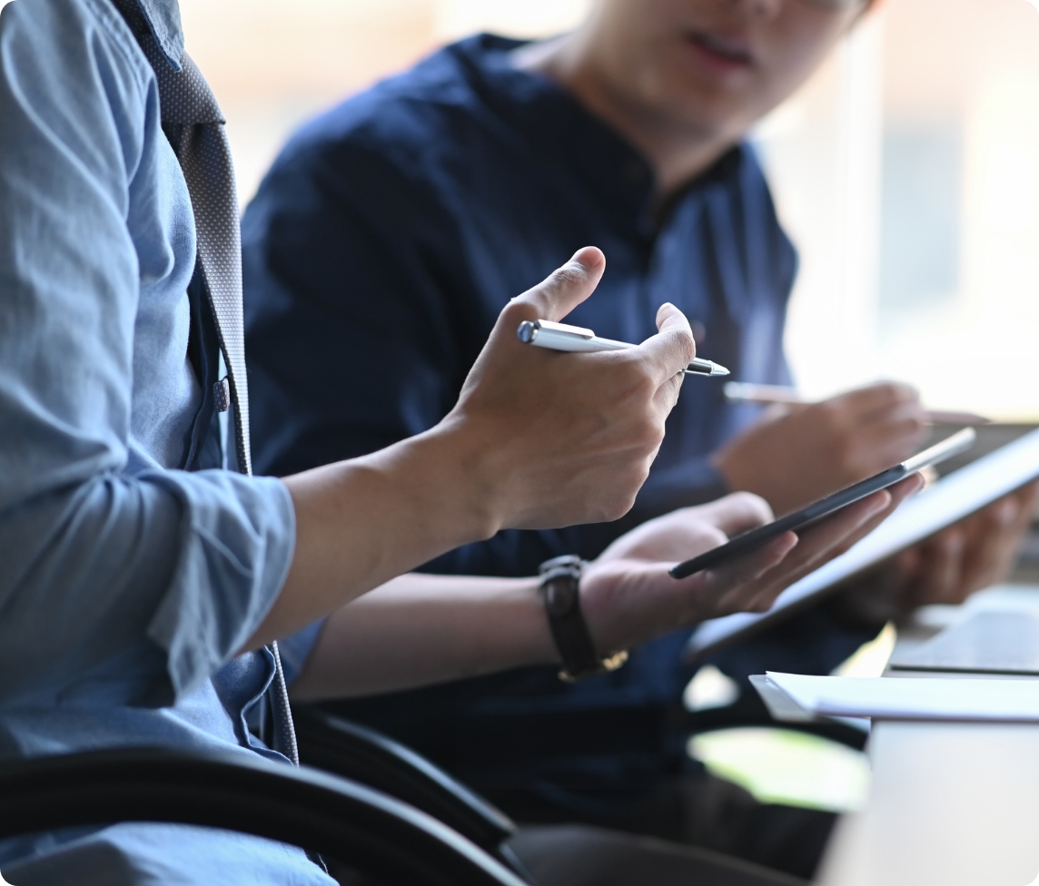 a man is holding a pen while looking at a tablet