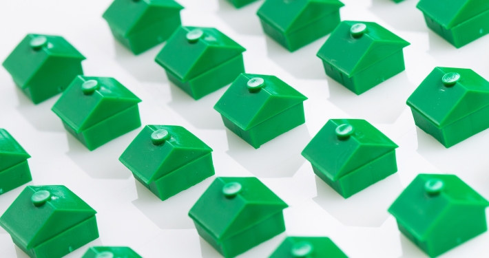 a bunch of green houses are lined up on a white surface