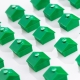 a bunch of green houses are lined up on a white surface