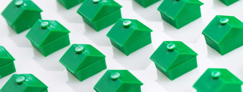 a bunch of green houses are lined up on a white surface